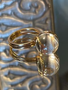 Rare 14k BRUTALIST MODERNIST POOLS OF LIGHT ROCK CRYSTAL GLASS ORB Ring!  in excellent condition! arrives in jewelry case and can be gifted immediately! crafted in solid 14k yellow gold - hallmarked and tested; came from Europe. weight approx 5.70g ; hand made solid gold - hammered like /organic surface - absolutely well made quality ring! orb is transparent and approx 12mm! GORGEOUS and RARE ring in excellent clean condition! smoke free environment; fast free USA priority insured shipping! for international please contact me. Formal Dome Ring With Vs Clarity, Gold Crystal Ring With Polished Finish For Formal Occasions, Modern Clear Round Jewelry, Luxury Clear Jewelry With Vs Clarity, Formal Yellow Gold Crystal Ring With Polished Finish, Modern 14k Gold Crystal Ring For Formal Occasions, Elegant Clear Rings For Formal Occasions, Modern Clear Wedding Rings, Formal Rings With Si Clarity, Round Shape