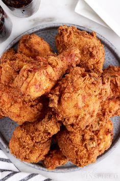 a plate full of fried chicken next to a fork and knife