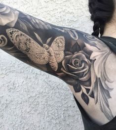 a woman with a butterfly and rose tattoo on her arm