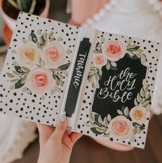 a person holding an open book with flowers on it and writing the word, be the bride