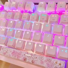 a close up view of a keyboard with pink and blue lights on it's side