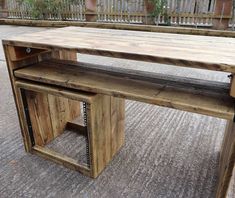 a wooden table sitting on top of a carpeted floor next to a metal fence