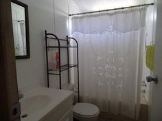 a bathroom with a toilet, sink and shower curtain