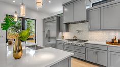 a kitchen with gray cabinets and white counter tops