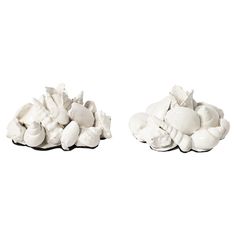 two pieces of white clay sitting on top of each other in front of a white background