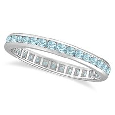 a white gold ring with blue topaz and channeled diamonds on the sides, set in