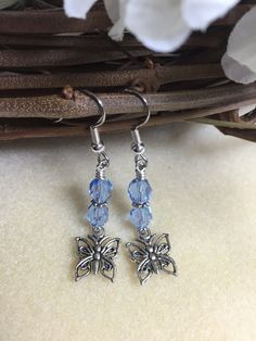 Earrings featuring light blue crystals and silver plated butterfly charms. Earrings are made using surgical steel ear wires. I use wrapped loops to give a finished look. Earrings come with rubber ear backs that slide on to keep earrings from falling out of ears.Color: sky blue crystalEarrings length: see pictureNot the right color? Not the right length? I can customize it just for you! I love doing custom orders!ORDERS PROCESS AND SHIP IN 1-3 BUSINESS DAYS. Large orders could take up to 4 days t Silver Butterfly Charm Drop Earrings, Adjustable Drop Earrings With Butterfly Charm, Nickel Free Light Blue Metal Earrings, Nickel-free Adjustable Butterfly Earrings, Adjustable Hypoallergenic Metal Crystal Earrings, Nickel-free Light Blue Dangle Earrings, Blue Butterfly Charm Dangle Earrings, Blue Dangle Earrings With Butterfly Charm, Adjustable Light Blue Earrings