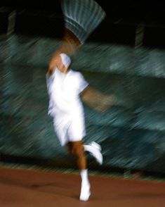 a man swinging a tennis racquet on top of a tennis court