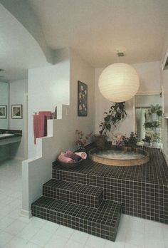 a bathroom with black and white tiled steps leading up to the bathtub in the corner