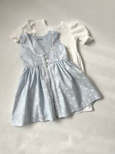 ✿ABOUT THIS DRESS ✓Our handmade set includes a white dress with front knot detail and a soft blue daisy flower-detailed toddler apron look.  ✓The white dress is also lined from the inside, providing extra comfort and durability. ✓The small daisy flower pattern on the apron adds cuteness to the overall look, making your little one look even more adorable.  ✿FABRIC INFORMATION ✓Natural cotton lining 100% under the skirt, cotton, terry cotton fabric. ✓Color of your item may vary slightly from what Cute Cotton Sundress For Daywear, Cute White Picnic Dress, White Cotton Sundress For Picnic, Cute White Dress For Picnics, Light Blue Sundress For Spring Garden Party, Light Blue Sundress For Garden Party In Spring, Cute Cotton Dresses For Day Out, Cute Cotton Dresses For Picnic, Cute Cotton Sundress For Spring