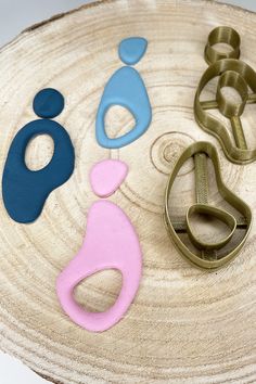 three cookie cutters sitting on top of a piece of wood next to each other