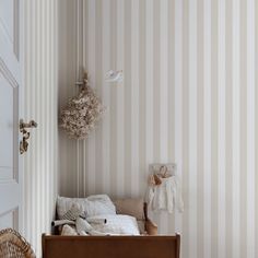 a bedroom with striped wallpaper and wooden flooring