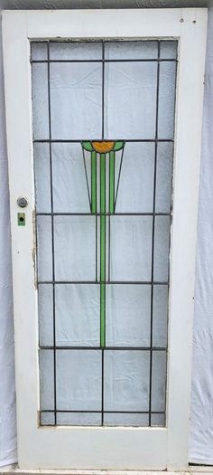 a stained glass door with a green and orange design on it's side window