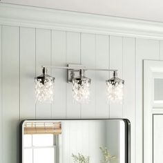 a bathroom vanity with three lights and a mirror