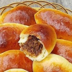 a basket filled with rolls covered in meat