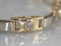 The proportions of this bracelet are excellent, with the sparkling bezel-set diamonds framed by elongated, polished gold bars. Incredibly proportioned, this gorgeous bracelet will transition easily from the office to the evening, making a wonderful gift that can be worn every day. Metal: 14K Yellow and White Gold Gem: 9 Diamonds totaling .72 Carats, SI1 in Clarity, H in Color Gem Measurements: 2.8 mm, Round Width: 6.0 mm Length: 7 Inches Marks: "14K" Stamped on the clasp Luxury Gold Bracelet With Bezel Setting, Luxury Gold Bracelet With Single Diamond, Elegant Gold Bracelet With Diamond Bezel Setting, Elegant Diamond Gold Bracelet With Bezel Setting, Modern Channel Set Diamond Bracelet For Anniversary, Timeless Gold Bracelet With Single Diamond For Formal Events, Timeless Gold Bracelet With Single Diamond For Formal Occasions, Elegant Channel Set Diamond Bracelet, Timeless Gold Diamond Bracelet With Bezel Setting