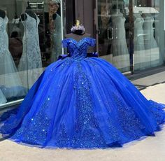 a blue ball gown on display in front of a store