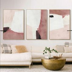 a living room with three paintings on the wall