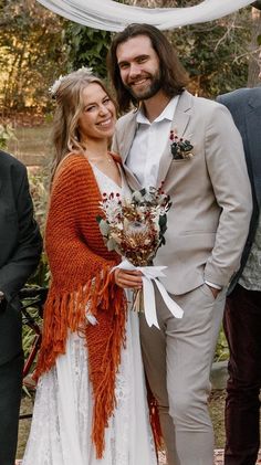 a man in a suit and tie standing next to a woman wearing a white dress