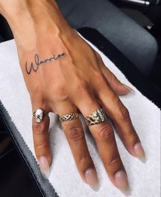 a woman's hand with two rings on it and the word women written in cursive writing