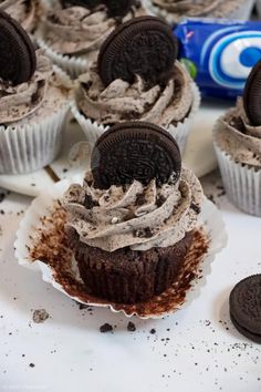 chocolate cupcakes with oreo cookies on top and frosting in the middle