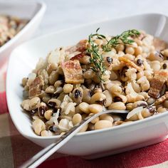 two white bowls filled with food on top of a table