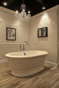 a large white bath tub sitting inside of a bathroom next to a chandelier