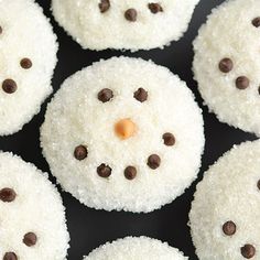 snowmen made out of rice krispy kreme treats on a black surface