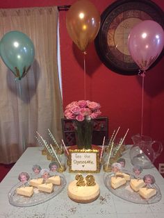 a table topped with lots of cake and balloons