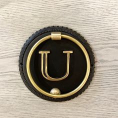 a black and gold object with the letter u on it