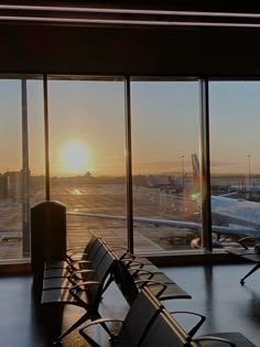 the sun is setting at an airport terminal