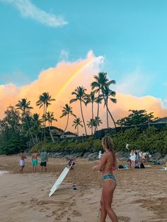 a group of people standing on top of a beach next to the ocean with surfboards