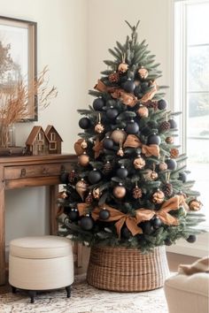 a christmas tree with black and gold ornaments in a basket next to a fireplace mantel