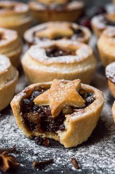 small pastries with cranberry fillings on a baking sheet covered in powdered sugar