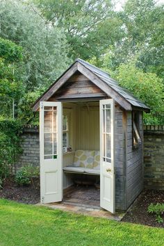 a small wooden shed sitting in the middle of a yard