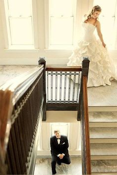 the bride and groom are posing on the stairs