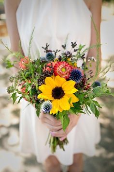 a woman holding a bouquet of flowers in her hands