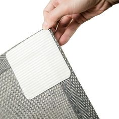 a person is holding a piece of fabric with the tag attached to it and two other pieces