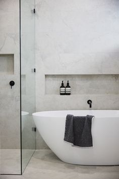 a white bath tub sitting next to a walk in shower