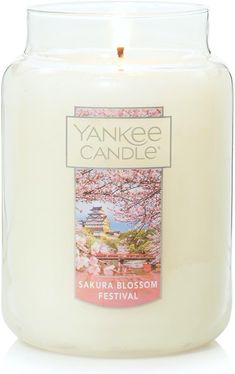 the yankee candle is white and has pink flowers on it's front, with an image of a pagoda in the background