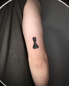 a black and white chess piece tattoo on the arm