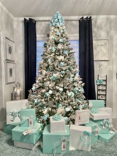 a white christmas tree with blue and silver presents