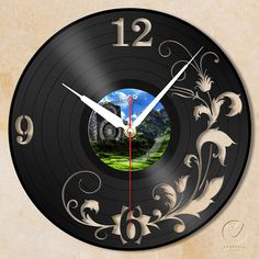 a wall clock with an image of a forest in the center and flowers on it