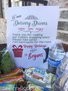 a sign that is next to some water bottles and food on a table in front of a building