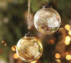 two glass ornaments hanging from a christmas tree