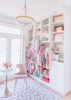 a white closet filled with lots of clothes next to a dining room table and chairs