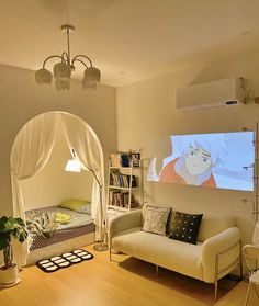 a living room with a couch, bookcases and a screen on the wall