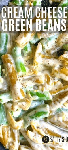 a close up of a pasta dish with cheese and green beans in it on a black plate