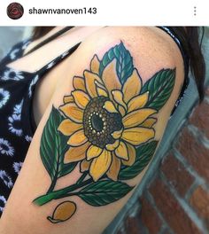 a woman's arm with a sunflower and leaves tattoo on the left shoulder