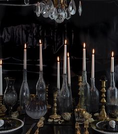 a table topped with lots of glass bottles and candles